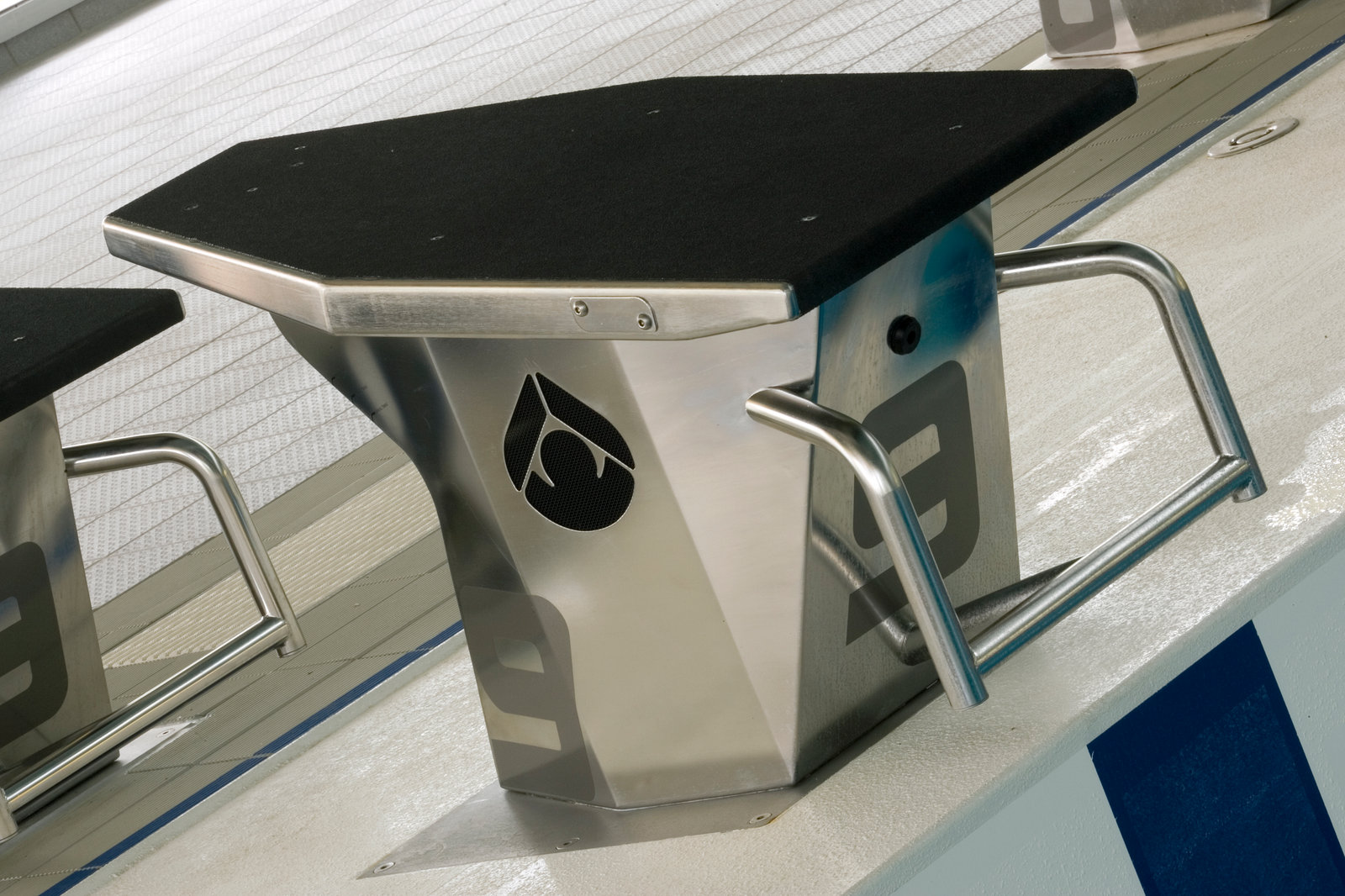Brushed stainless steel swimming starting platform on a pool deck